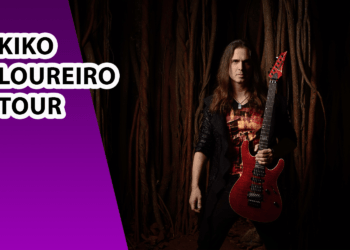 Foto: Henrique Grandi Esta é uma imagem promocional para a turnê de Kiko Loureiro. O fundo é roxo à esquerda e apresenta um ambiente urbano com prédios altos e palmeiras à direita. O texto principal, 'KIKO LOUREIRO TOUR', está em letras grandes, pretas com contorno branco. À direita, há uma imagem do guitarrista Kiko Loureiro segurando uma guitarra elétrica verde e preta, vestindo uma jaqueta verde e um colar com pingente de coração. A imagem transmite um estilo moderno e vibrante.