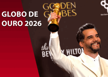 Wagner Moura sorridente segurando a estatueta dourada do Globo de Ouro. Ele veste um terno branco. À esquerda, um bloco bordô com o texto "GLOBO DE OURO 2026".