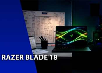 Laptop gamer Razer Blade 18 aberto sobre uma mesa de escritório, exibindo papel de parede de linhas fluidas verdes na tela. À esquerda, uma faixa azul inclinada com o texto "RAZER BLADE 18".
