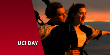 Os personagens Jack e Rose na icônica cena da proa do navio no filme Titanic, durante o pôr do sol. À esquerda, uma faixa vermelha inclinada com o texto "UCI DAY".
