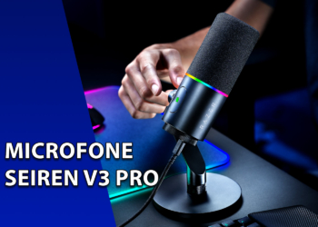 Microfone condensador Razer Seiren V3 Pro posicionado em um pedestal de mesa, com iluminação RGB ativa e uma mão ajustando o botão de controle. À esquerda, uma faixa azul inclinada com o texto "MICROFONE SEIREN V3 PRO".