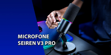 Microfone condensador Razer Seiren V3 Pro posicionado em um pedestal de mesa, com iluminação RGB ativa e uma mão ajustando o botão de controle. À esquerda, uma faixa azul inclinada com o texto "MICROFONE SEIREN V3 PRO".